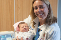 Dr. Goetz with a newborn who has just passed the POX screen.